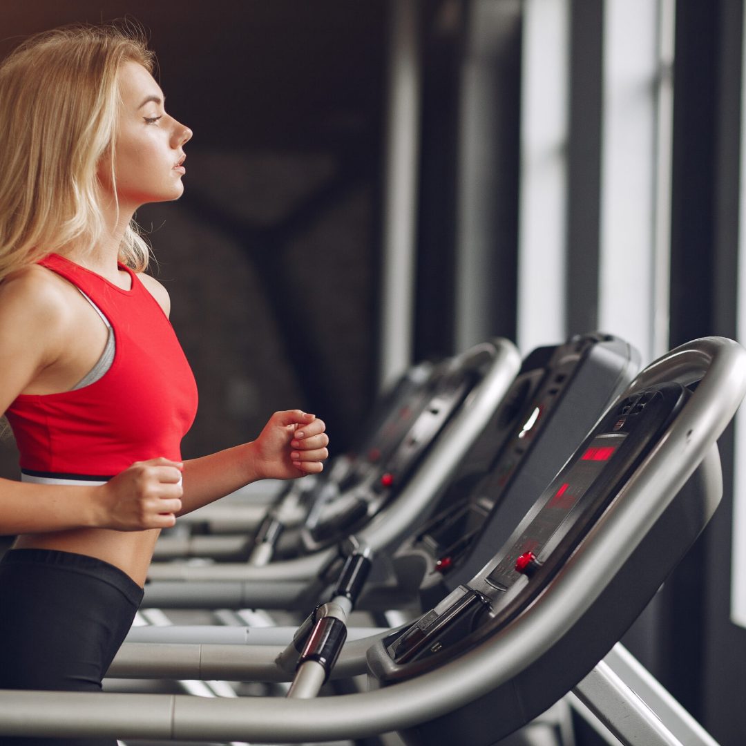 Girl in a gym. Woman on a racetrack. Lady in a red top.